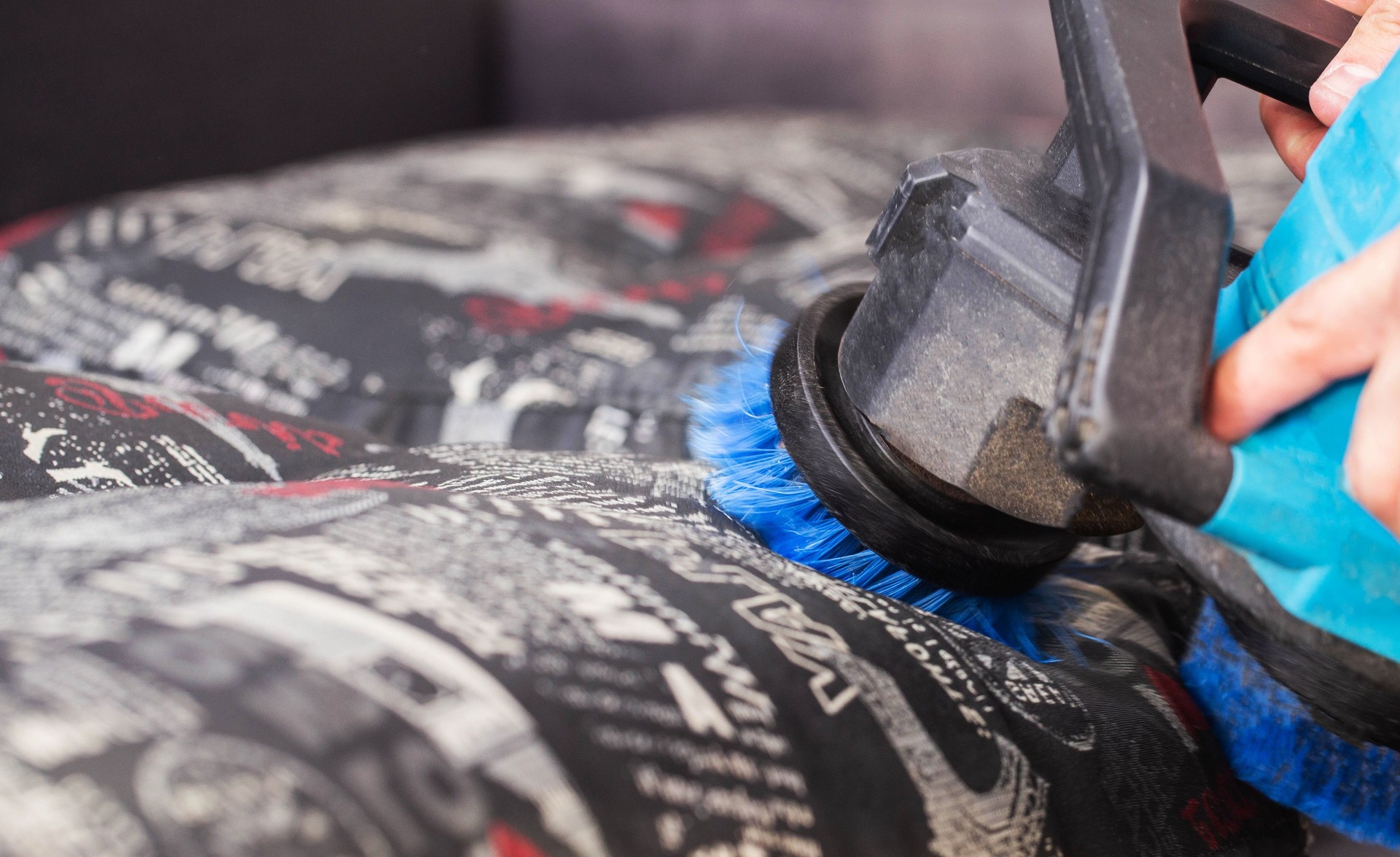 Dry cleaning of the sofa with a special electric brush to raise the pile, close-up.